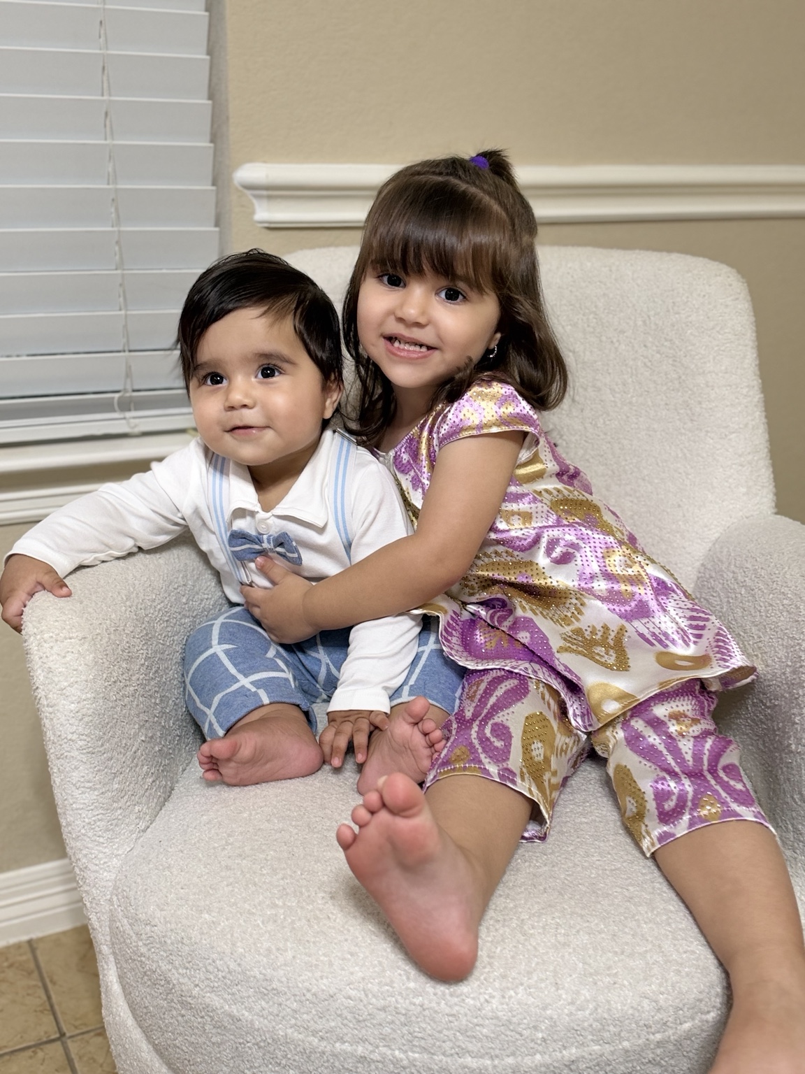 Alia hugs Aariz as they sit together on a cream armchair